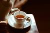 Tea being poured into a cup and saucer