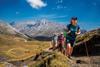 A group of walkers head up a mountain against an incredible view