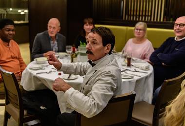 Manuel with diners at the Faulty Towers The Dining Experience in London